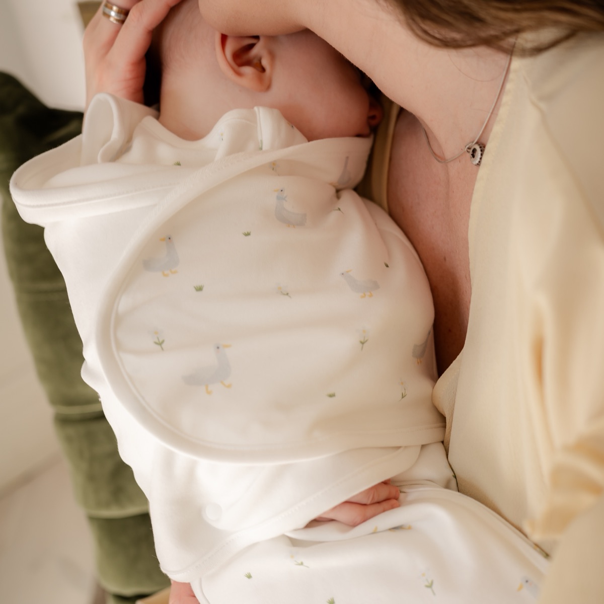 A mother holding her swaddled newborn