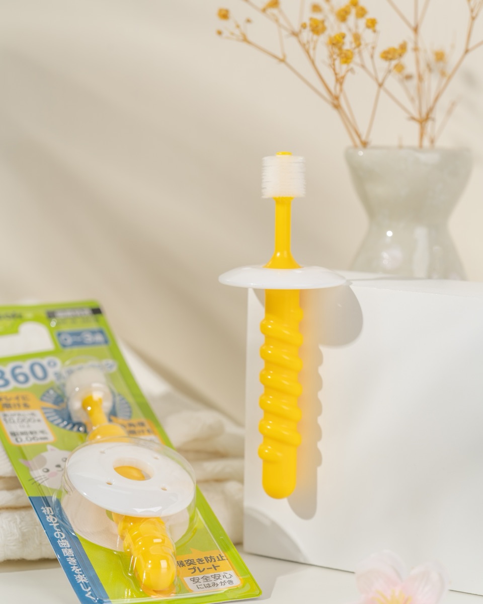 A Plusoft 360° toothbrush beside its pack